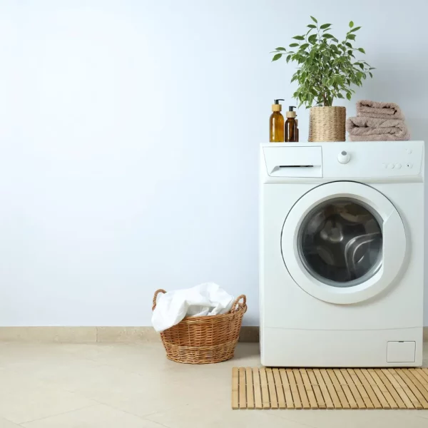 concept-housework-with-washing-machine-against-white-wall