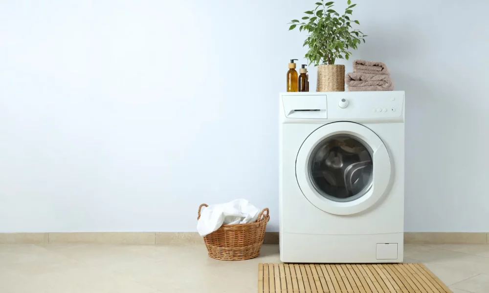 concept-housework-with-washing-machine-against-white-wall