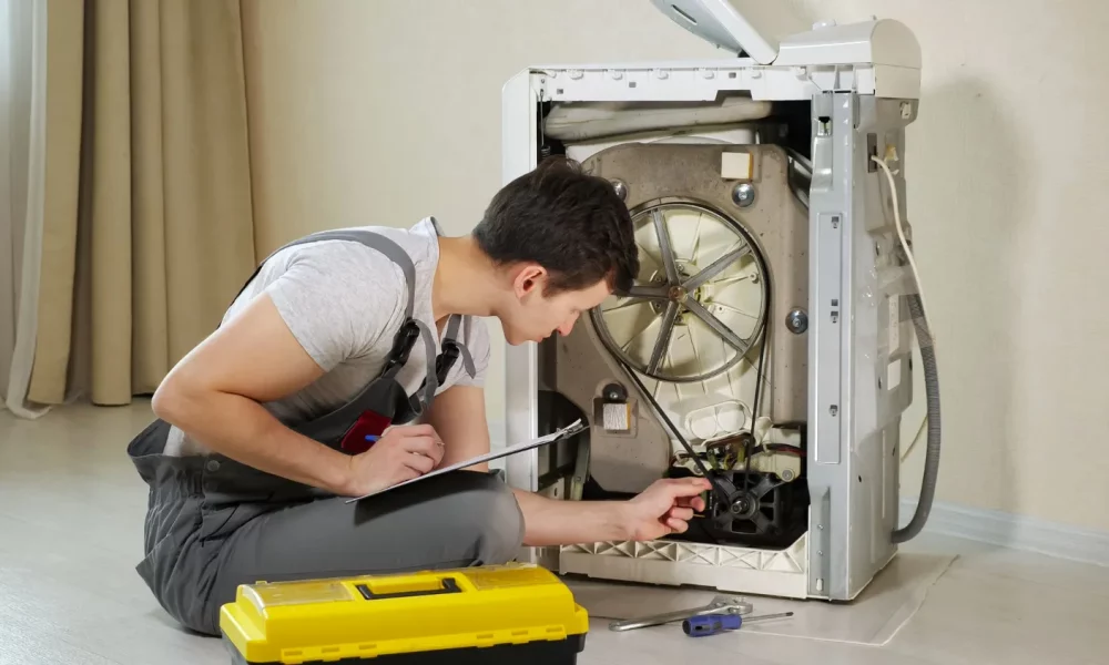 serviceman-checks-washing-machine-floor-room-closeup
